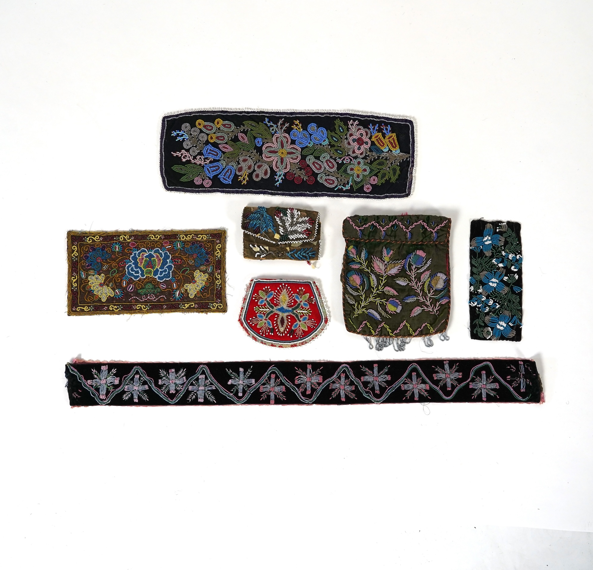 A 19th century black felt multi coloured beadwork panel, possibly North American Indian and a similar purse, a Regency fine bead worked bible bag, a similar worked belt and small panel, a red bead work purse and a small